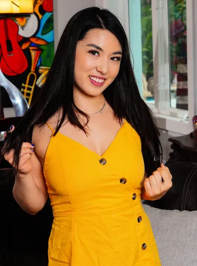 Mina Moon Smiles While Spreading Legs on Couch